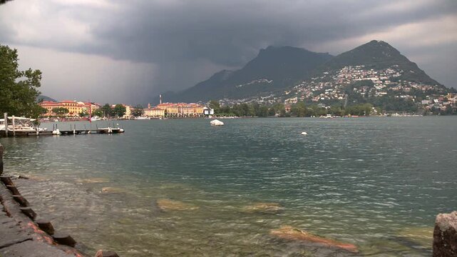 Lugano city on Lake Lugano, Switzerland in a summer day with the arrival of a storm. On the right you can see the Monte Br&egrave;