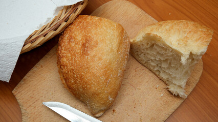 Freshly baked bread ready for slicing on a wooden cutting board