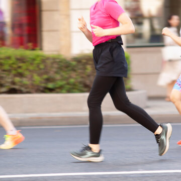 female athlete jogs along a summer street in the city