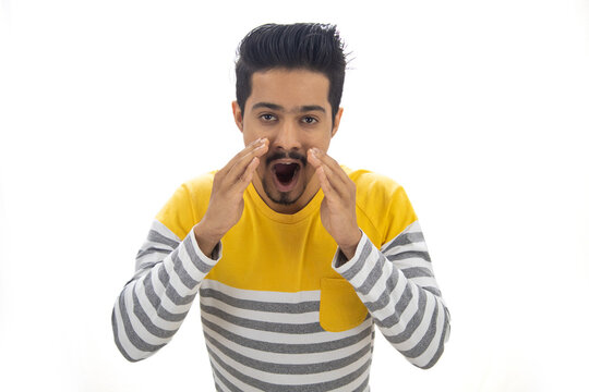 Young man shouting message using cupped hands
