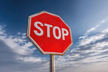 Obraz premium Red and white stop sign against a cloudy blue sky