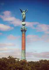 Fototapeta premium Victoria statue on the admiral Ivar Huitfeldt Column (1886) against a cloudy blue sky in Copenhagen, Denmark