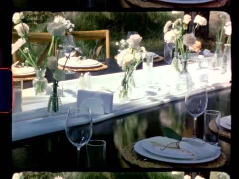 Authentic Super 8mm film shot of a rustic wedding reception table set in a pine forest.