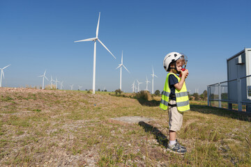 Children are running on a natural energy farm such as windmills and electricity.