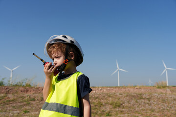 Children are running on a natural energy farm such as windmills and electricity.