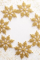 Sparkling Gold Glitter Snowflakes Arranged in a Circular Wreath Pattern on a White Textured Background with Scattered Glitter Dust for Festive Winter Holiday Celebrations