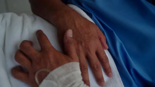 Elderly Asian cancer patient man lying on hospital bed suffers from severe stomach pain and diarrhea. Health insurance for treatment support.
