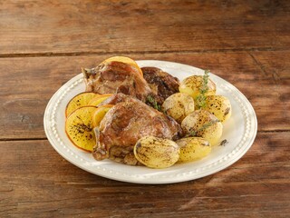 Juicy chicken thighs topped with melted mozzarella are served alongside perfectly roasted potatoes and zesty lemon slices on a charming wooden table