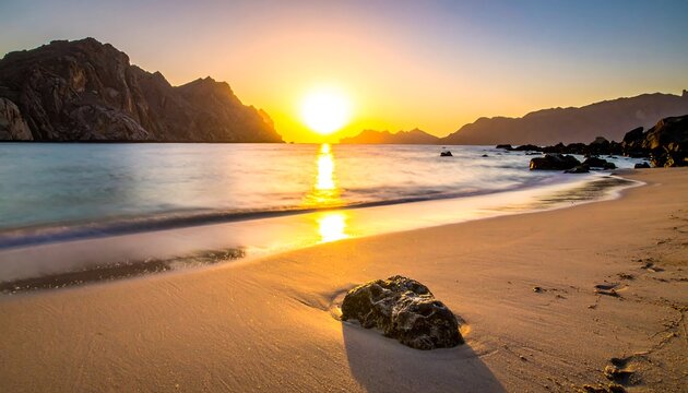 Golden hour paints the serene beach scene with a low, bright sun, rocky hills, and gentle waves