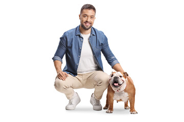 Happy young man kneeling and posing with an english bulldog