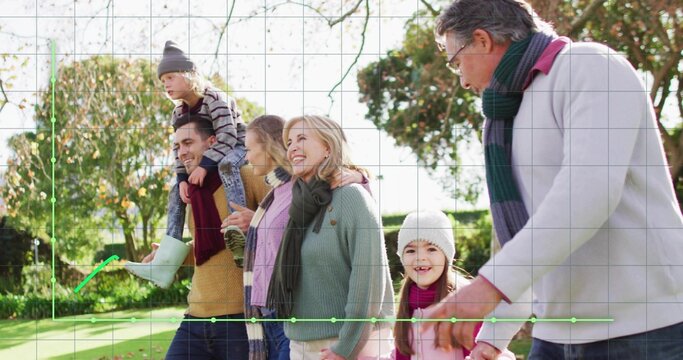 Walking three generation family wearing coats and scarves in sunlit park, showing grid overlay - Powered by Adobe