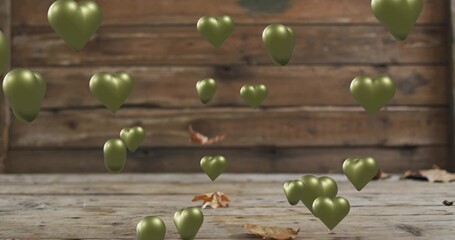 Naklejka premium Floating olive-green heart-shaped metallic balloons with plank wall, wooden floor, dry leaves