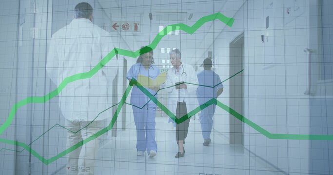 Walking nurse in scrubs and doctor in white coat talking in hospital, holding charts, green graphs