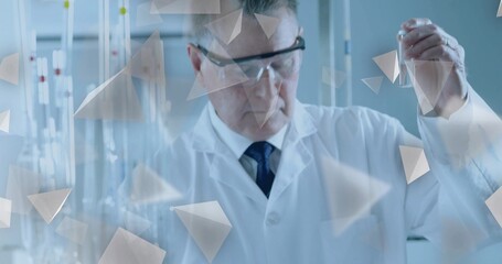 Holding test tube, scientist examining solution at lab bench with burettes, lab coat and goggles
