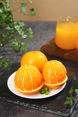 Fresh Sweet Navel Oranges Peeled and Segmented with Orange Juice and Mint Garnish on Rustic Wood Table