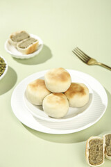 Traditional Mung Bean Dessert Buns with Golden Crisp Tops on White Plate - Asian Sweet Confectionery