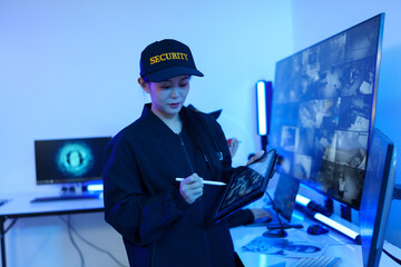 Security officers are checking the TV screen of the CCTV system. 