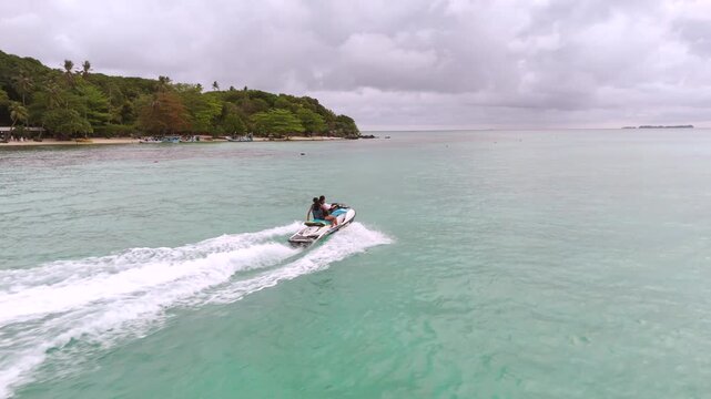 Aerial View of Tourists Enjoying Jet Ski Ride in Turquoise Sea Water on Karimunjawa Island Beach