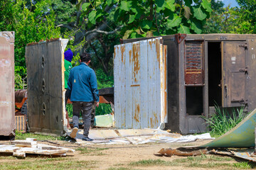 Construction Workers Dismantling and Recycling Old Container Panels Outdoors