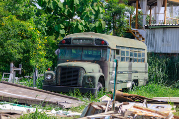 Abandoned Vintage School Bus Painted in Military Camouflage, Junkyard or Glamping Spot