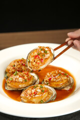 Steamed Fresh Abalone with Garlic Sauce Asian Seafood Dish Served with Chopsticks
