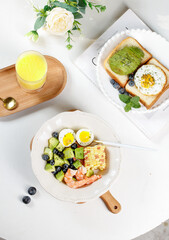 Healthy breakfast salad with shrimp, avocado and eggs served with toast and fresh orange juice