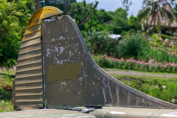 Abandoned Military Helicopter Wreckage and Engine on Display Near Thatched Huts