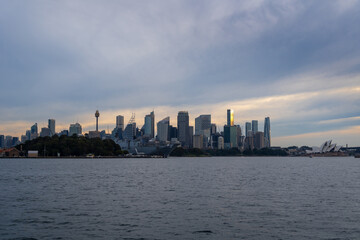 Obraz premium Sydney skyline at sunset with golden reflections on the water