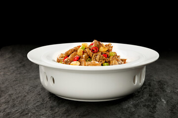 Spicy Stir-Fried Chicken and Beef with Fresh Vegetables in White Bowl - Traditional Asian Cuisine Dish