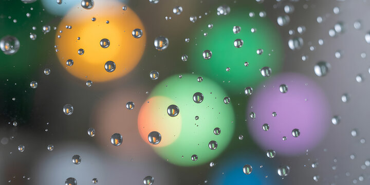 Macro photo of water droplets on glass with colorful bokeh background creates a mesmerizing abstract texture vibrant colors and reflective surfaces offer a unique and artistic composition