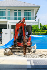 Small Mini Excavator with Hydraulic Breaker Jackhammer Drilling Concrete on Construction Site