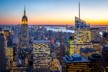 Aerial view of the iconic Manhattan in New York, USA at night with its famous skyscrapers and lights.