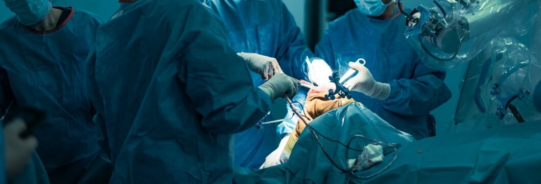 Surgeons in a sterile operating room are performing knee replacement surgery with the robotical surgery knee system, utilizing robotic assistance for precise bone resection