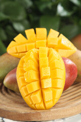 Fresh Ripe Mango Cut in Cubes on Wooden Board with Red Skin and Tropical Background
