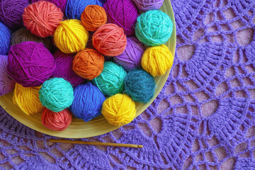Knitting and hobbies concepts. Colorful balls of yarn and crochet hook. Knitted background