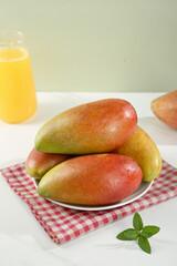 Fresh Tree-Ripened Mangoes on Plate with Orange Juice - Tropical Fruit Display