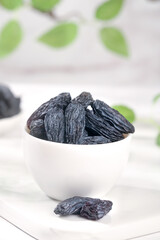 Black Raisins in White Bowl - Healthy Dried Fruit Snack with Natural Background