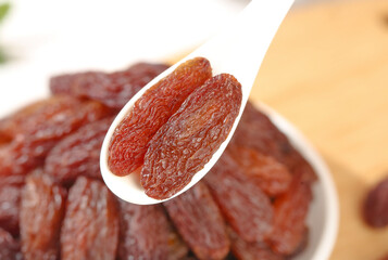 Ruby Red Dried Raisins from Turpan Xinjiang China on Wooden Spoon - Premium Dehydrated Grapes