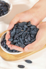 Dried Black Raisins from Xinjiang Turpan Region Held in Cupped Hands - Healthy Dried Fruit Snack