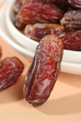 Premium Dried Dates Fruit Close-up with Golden Brown Texture in White Bowl on Wood Background