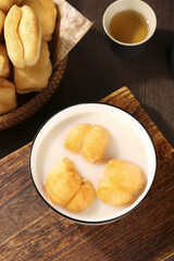 Traditional Crispy Little Fritters in Milk Bowl - Delicious Breakfast with Tea and Bread on Wooden Table