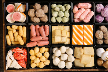 Asian Hotpot Ingredients Variety Platter with Beef Balls Fish Cakes Tofu Sausages and Other Delicious Delicacies in Black Serving Trays