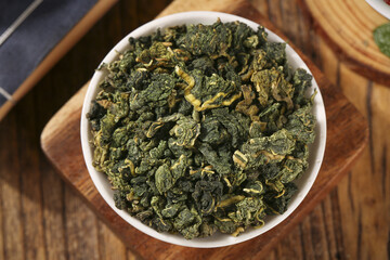 Dried Mulberry Leaves Herbal Tea in Bowl - Healthy Natural Alpine Drink Ingredients on Wood