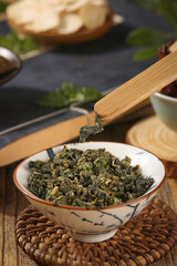 Dried Mulberry Leaves Tea Ingredients in Traditional Ceramic Bowl with Bamboo Spoon