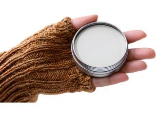 Hand in brown knitted sleeve holding metal balm tin isolated on transparent background, perfect for skincare or winter self-care concepts.