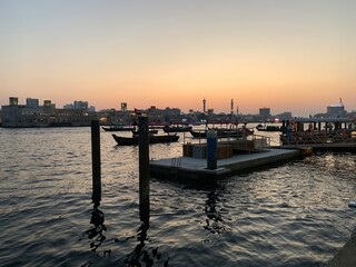 Sunset over the historic Dubai Creek with traditional boats