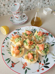 Pastry tartlet with cream cheese on plate. Appetizers made from cucumber, avocado, and salmon. Cooking at home. Mediterranean cuisine. 