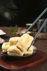 Traditional crispy Chinese fried dough sticks youtiao breakfast food with chopsticks in cast iron pan