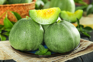 Fresh Honeydew Melon Slices with Green Skin and Yellow Flesh on Rustic Wooden Table