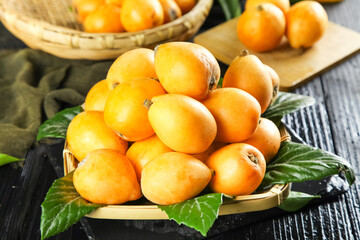 Fresh Loquat Fruits in Wicker Baskets - Golden Orange Asian Miyi Alpine Fruits with Green Leaves